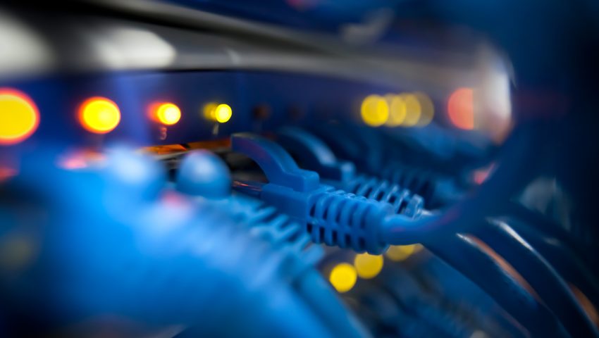 Selective focus closeup view of cables plugged into a server network panel with lights indicating activity. Photographed inside an equipment room.  Canon 5D MarkII. The file has been meticulously retouched in Photoshop eliminating dust and unwanted flaws. I have over 22 years experience as a photo retoucher.